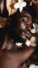 A serene portrait of an African man surrounded by plumeria flowers and leaves