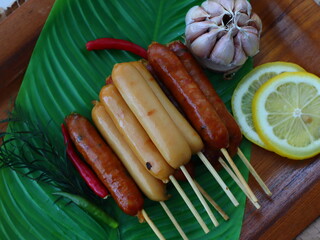 Grilled fermented pork sausage (Naem Yang) — a popular Thai snack with tangy, smoky flavors, grilled to perfection for a crispy exterior and chewy inside.