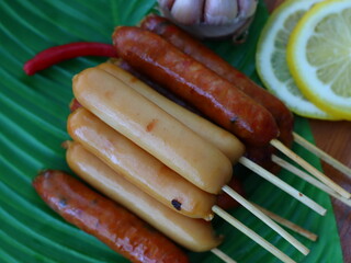 Grilled fermented pork sausage (Naem Yang) — a popular Thai snack with tangy, smoky flavors, grilled to perfection for a crispy exterior and chewy inside.