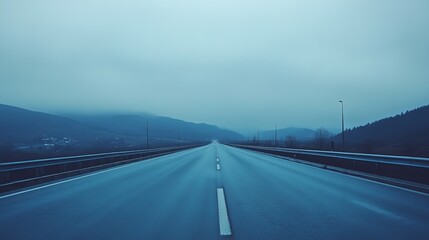 Empty highway stretching into a misty, bluish landscape