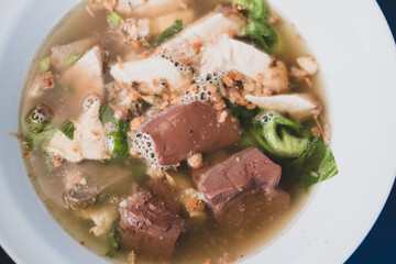 Pork entrails and blood jelly soup with vegetable in bowl.