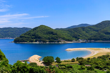 澄んだ青い海と緑の山が広がるムーンビーチ井野浦の絶景風景

