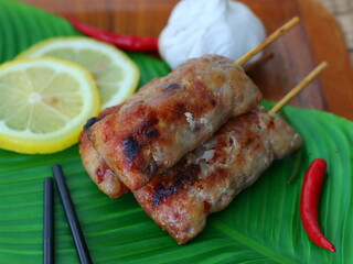 Grilled fermented pork sausage (Naem Yang) — a popular Thai snack with tangy, smoky flavors, grilled to perfection for a crispy exterior and chewy inside.