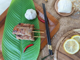 Grilled fermented pork sausage (Naem Yang) — a popular Thai snack with tangy, smoky flavors, grilled to perfection for a crispy exterior and chewy inside.
