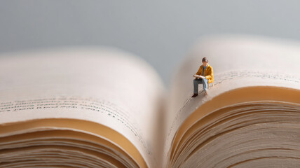 miniature student reading on big book symbolize education concept