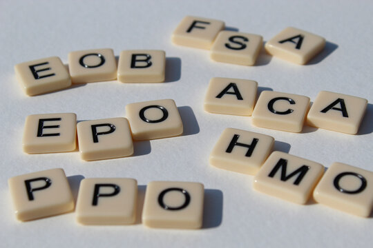 Several health insurance acronyms design element with letter tiles isolated on white. Making sense of common terms. Business or human resources design element.