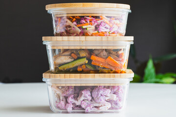 ガラスの保存容器に入った、作り置きの家庭料理（鶏肉と野菜の炒め物、紫カリフラワーのマスタードマヨサラダ）