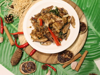 Stir-fried mackerel with Thai basil — a flavorful Thai home-style dish made with fried short mackerel (Pla Too), stir-fried with garlic, chili, and fresh holy basil leaves. Rich in aroma and spicy fla