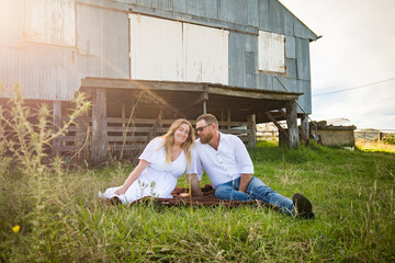 Romantic portrait of man and woman sitting together on farm