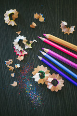 Colorful Pencil Shavings and Sharpened Pencils on Dark Surface
