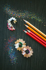 Colorful Pencil Shavings and Sharpened Pencils on Dark Surface