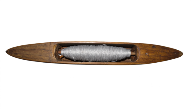 Vintage wooden shuttle filled with silver thread, a timeless tool for textile creation and craftsmanship