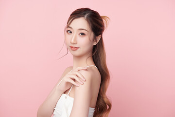 A beautiful young Asian woman with clean, fresh skin against a pink background. Skincare, facial treatment, cosmetology, beauty, and spa. An elegant portrait of an Asian woman.