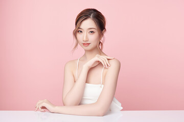 A beautiful young Asian woman with clean, fresh skin against a pink background. Skincare, facial treatment, cosmetology, beauty, and spa. An elegant portrait of an Asian woman.