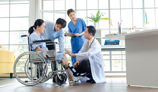 Asian doctor physiotherapy check splint leg support to senior old woman patient assisted by caregiver and nurse medical orthopedic trauma treatment team providing rehabilitation in a healthcare clinic - Powered by Adobe