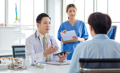 Asian male doctor consulting explaining talking  medications to patient sick assisted by caregiver nurse professional support trust healthcare checkup insurance treatment wellness in hospital clinic.