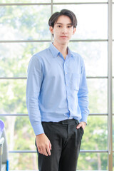 Portrait asian happy professional young businessman confident standing smiling look at camera male leader executive manager entrepreneur company executive employee owner standing in modern work office