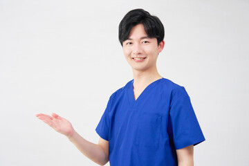 医者・看護師・歯科医師・介護士　左側を手のひらで指す男性　白背景
