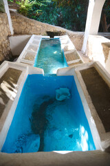 Outdoor traditional lavajo with detailed basins and serene water flow surrounded by lush greenery, symbolizing historical utility and serene ambiance, perfect for representing traditional