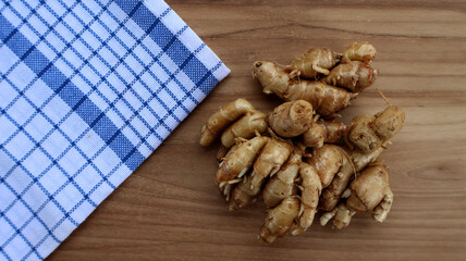 Aromatic ginger on wooden surface with blue kitchen towel