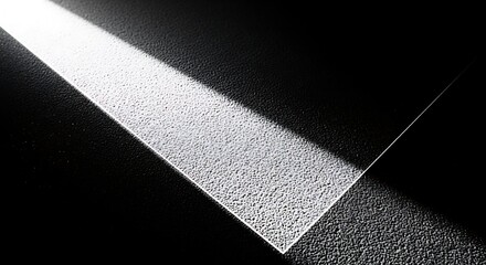 Sharp light beam illuminates textured surface in darkness