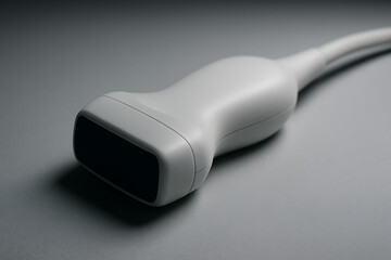 Close-up of medical ultrasound probe device on gray background, diagnostic imaging equipment, sonography scanner sensor, radiology tool for health monitoring, non-invasive medical examination device

