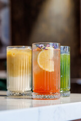 Assorted summer lemonades in glass jars with fresh fruits, ice, and garnishes