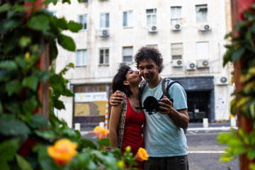 Kiss on the street. Reflection of happy kissing couple taking selfie on camera in mirror. Creative concept of young family, relationships and love.