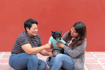 Couple of two brunette Latina lesbians show their love for the dog that is their pet and part of...