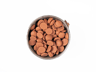 Top view close-up of a cup filled with chocolate granules on white background