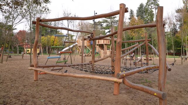 Crow lands on wooden climbing frame at playground and flies away &ndash; urban wildlife behavior