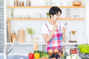 キッチンで献立を考える主婦。