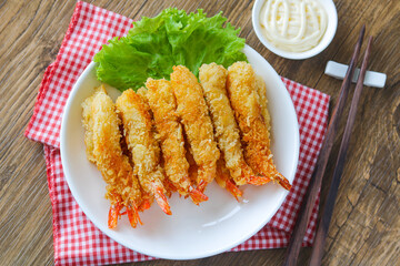 A plate of crispy golden fried shrimp (Ebi Fry or Tempura), garnished with fresh lettuce and served...