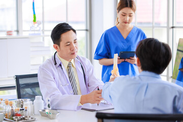 Fototapeta premium Asian male doctor consulting explain medications to senior female patient assisted by caregiver and nurse professional support trust healthcare checkup, insurance treatment wellness in hospital clinic