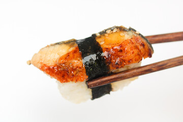 A single piece of perfectly formed Unagi Nigiri sushi, featuring glazed grilled eel atop a bed of...