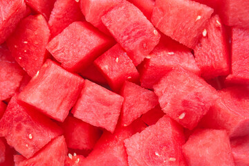 A close-up image of fresh watermelon cubes stacked together. The vibrant red color and juicy texture highlight the refreshing and hydrating nature of this tropical fruit.