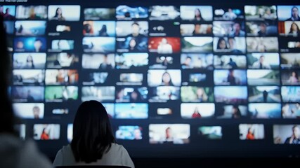 Person viewing many video feeds on a large screen - Powered by Adobe
