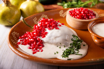 Chiles en Nogada, Typical dish from Mexico. Prepared with poblano chili stuffed with meat and fruits and covered with a walnut sauce, parsley and pomegranate.