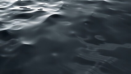 A close up view of dark water with gentle ripples and subtle light reflections on the surface