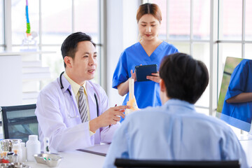Fototapeta premium Asian male doctor consulting explain medications to senior female patient assisted by caregiver and nurse professional support trust healthcare checkup, insurance treatment wellness in hospital clinic