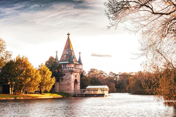 Medieval Franzensburg castle and small ferry on lake in autumn Laxenburg park, Lower Austria