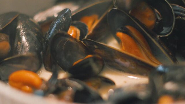 Close Up of Cooked Mussels in White Wine Sauce Ready to be Eaten with Hands. Delicious Seafood Healthy Shellfish Starter.