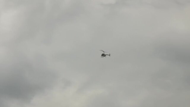 The helicopter flies in cloudy weather