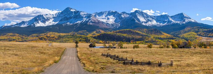 Autumn Mountain Country-Road - A panoramic Autumn view of a country road extending towards towering snow-capped Wilson Peak. Telluride, Colorado, USA.