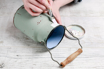 Woman is renovating an old steel bucket. Step by step, tutorial.