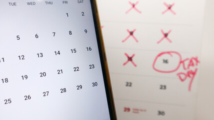A smartphone calendar is next to a physical calendar with 