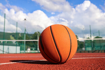 A classic orange basketball on an outdoor court.