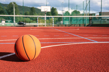 A classic orange basketball on an outdoor court.