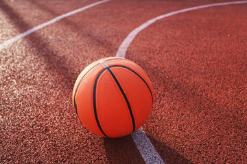 A classic orange basketball on an outdoor court.