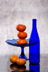 Still life with a blue bottle and tangerines
